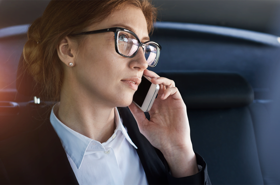 red haired woman with glasses on mobile phone